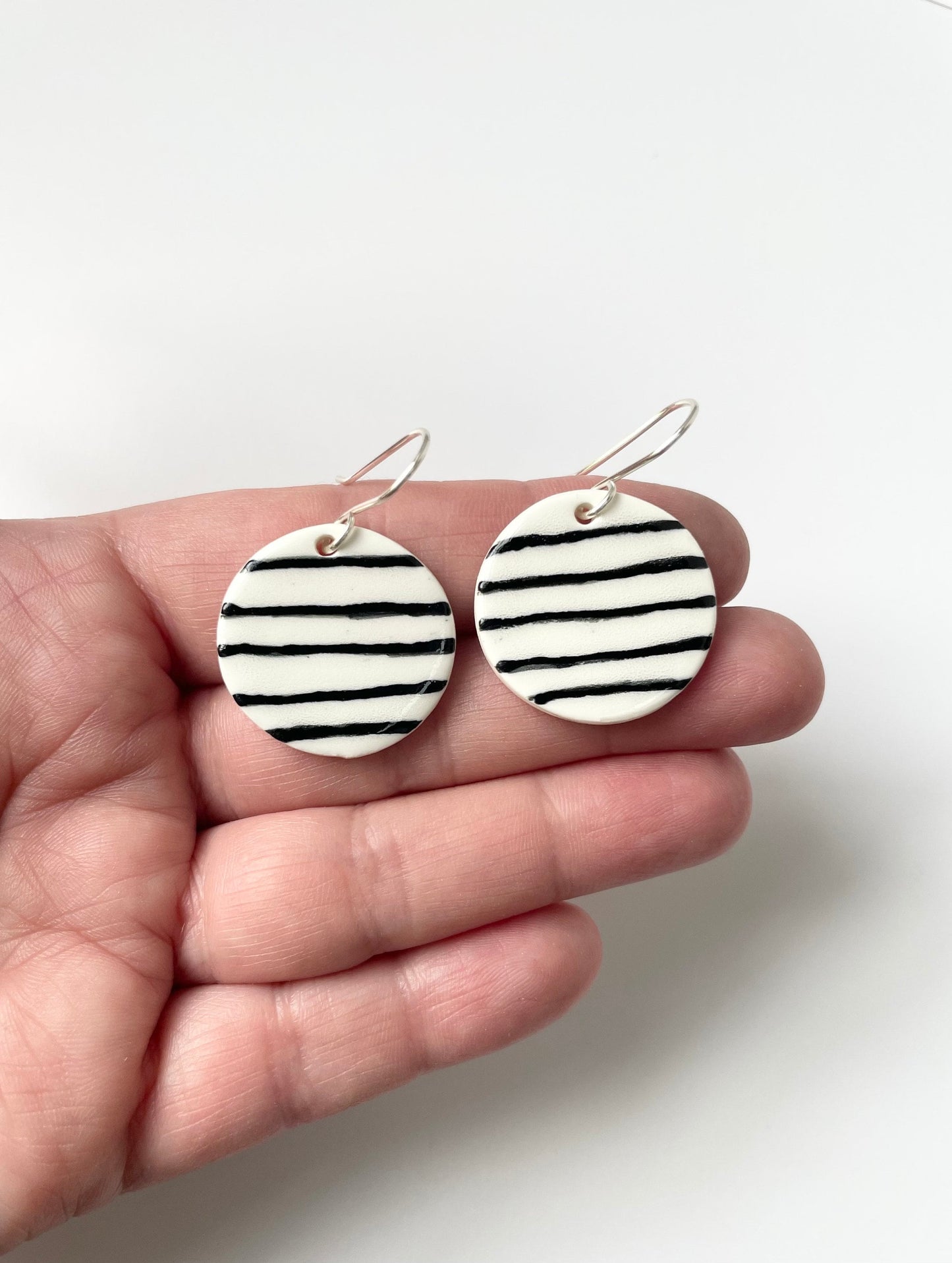 Round White earrings with black stripes