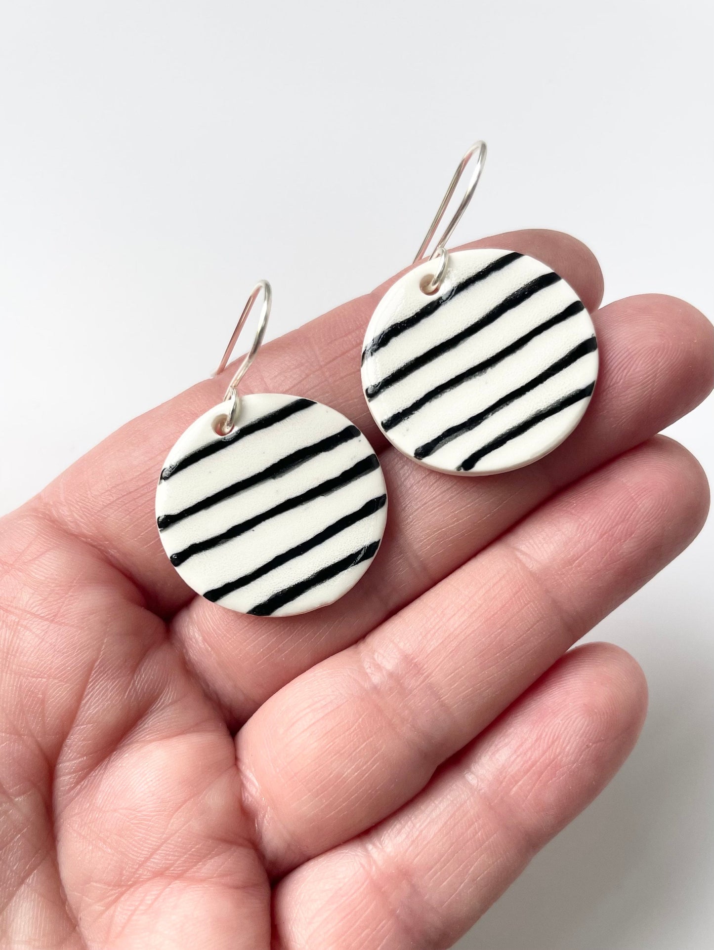 Round White earrings with black stripes