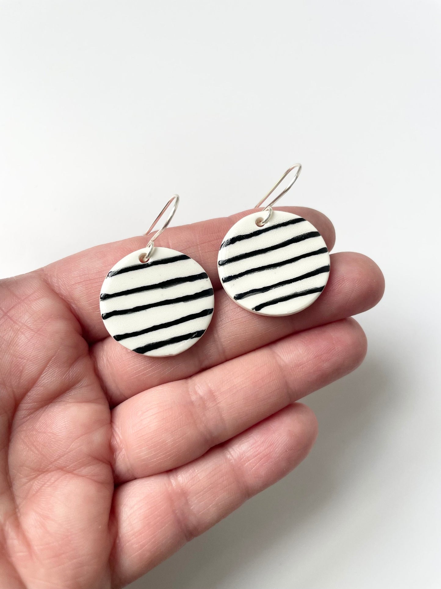 Round White earrings with black stripes